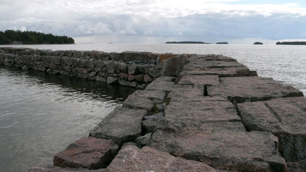 Stony breakwater in the Baltic Sea. Cloudy summer day.