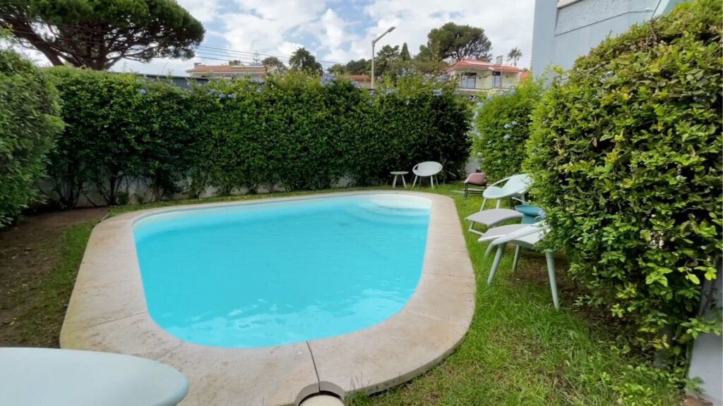 Small garden with a pool and chairs.